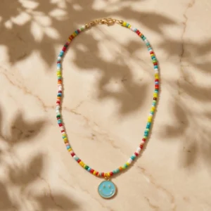Colourful beaded Smiley Coin Necklace on a marble background
