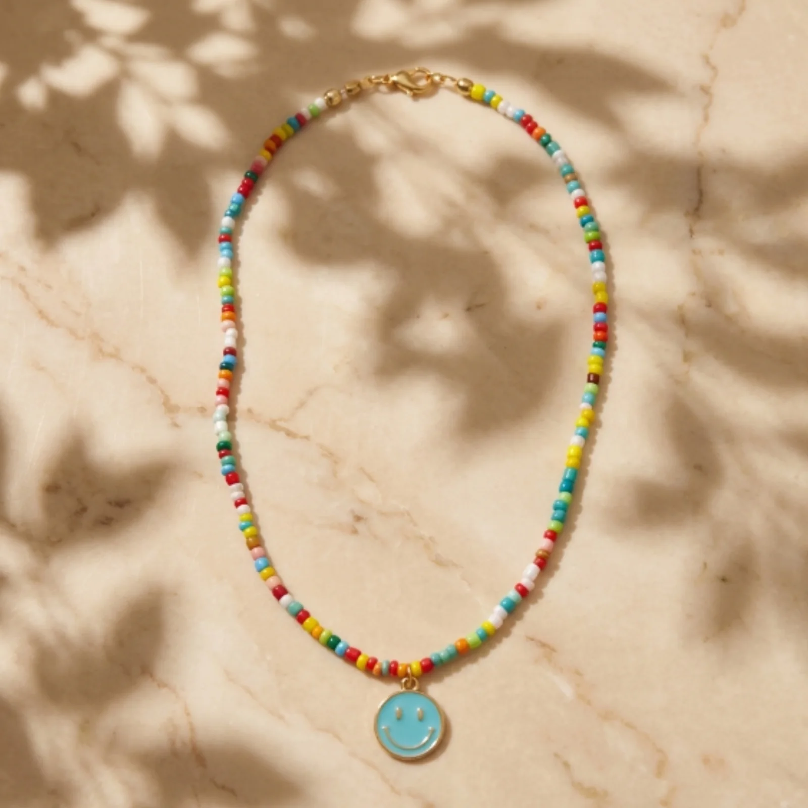 Colourful beaded Smiley Coin Necklace on a marble background