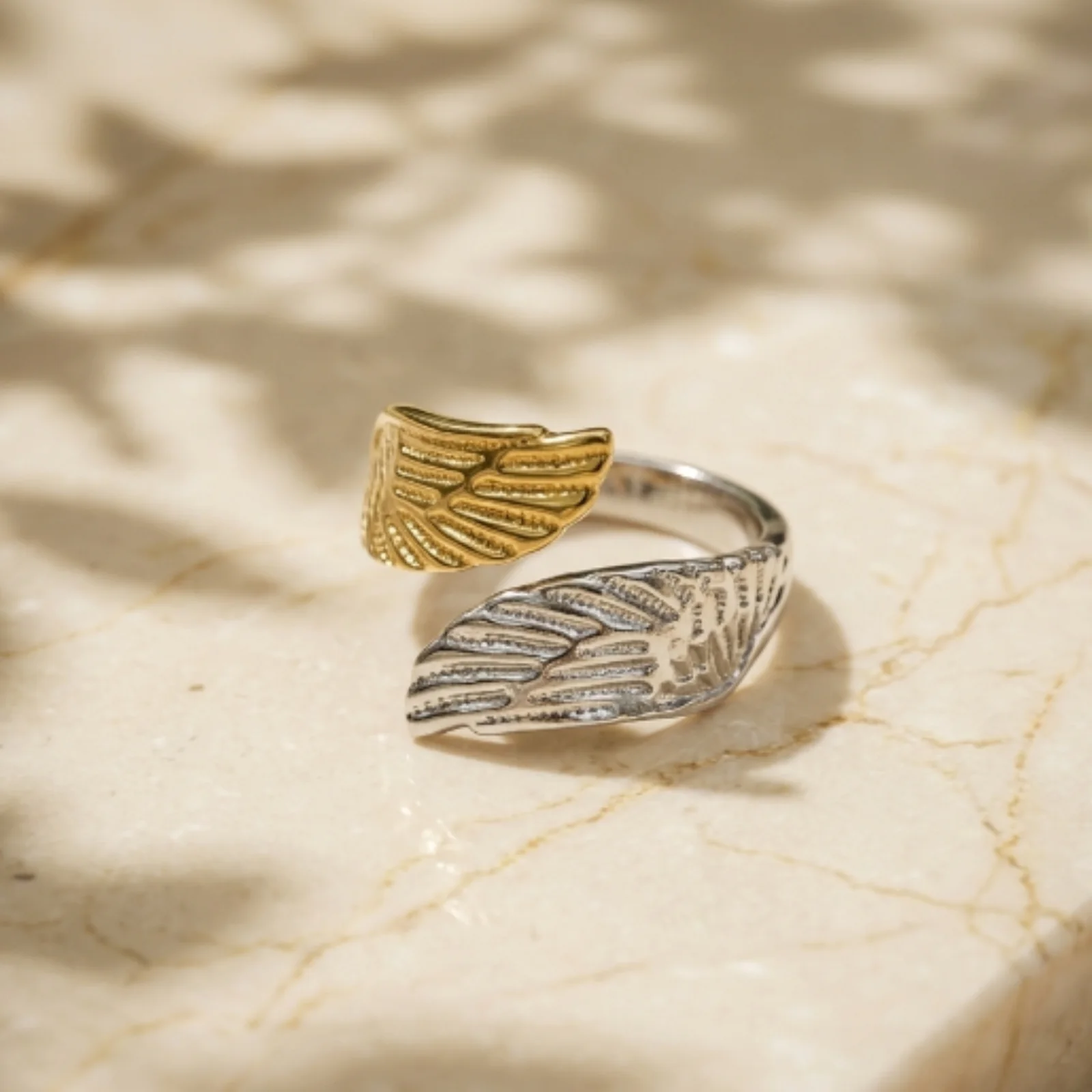 Two-tone Winged Ring photographed on a marble background